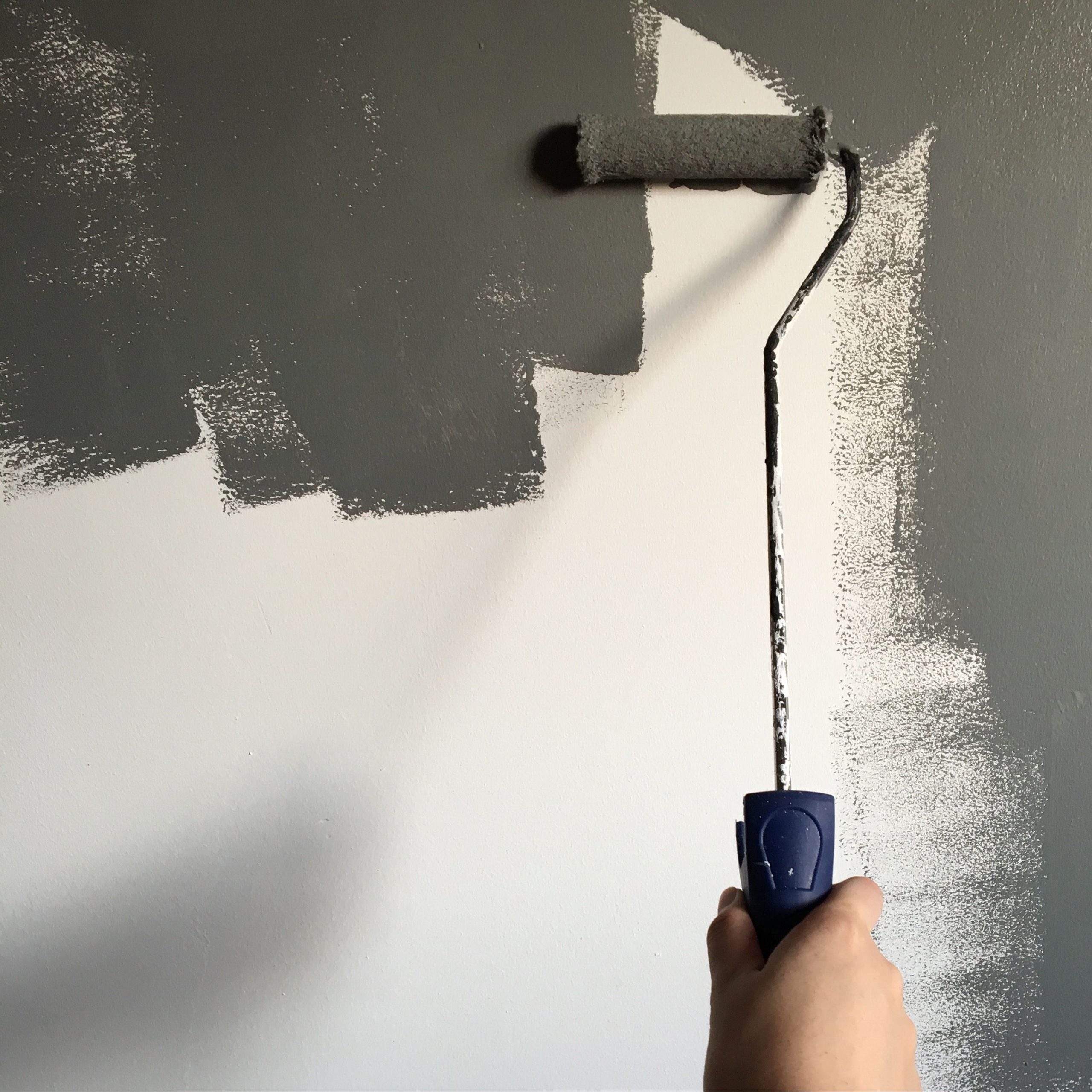 Professional painter painting a wall with a roller in a Reading home